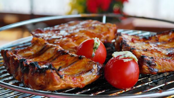 BBQ ribs on a grill with tomatoes
